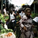Local trader walks past a bustling market in Lagos, Nigeria, where small businesses are likely to be impacted by the country's tightening monetary policy.