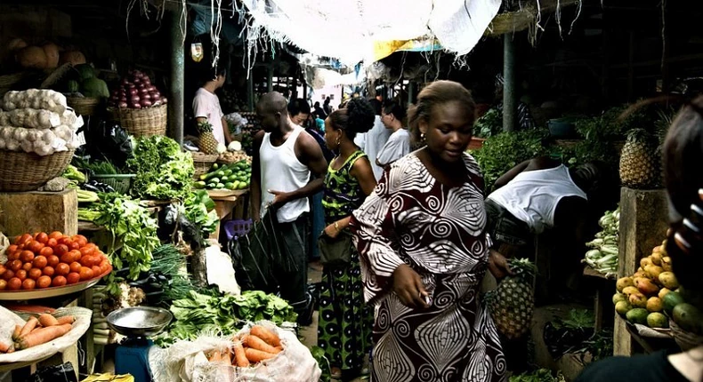Local trader walks past a bustling market in Lagos, Nigeria, where small businesses are likely to be impacted by the country's tightening monetary policy.